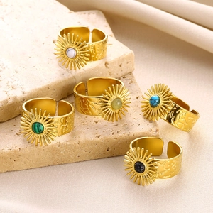 Detail of five adjustable gold rings with turquoise stones in vintage sunflower design