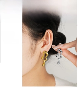Detail shot of irregular liquid metal drop earrings in polished gold and silver finish