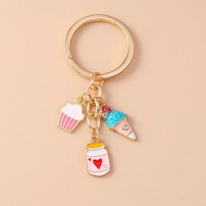 Detail of gold keychain with enamel cupcake, jam jar, and rhinestone ice cream charms