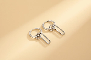 Macro detail of silver-finish tiered oval hoops showing high-shine metal texture