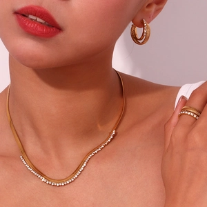 Golden necklace, earrings and ring set with micro-inlaid zircons worn by a model