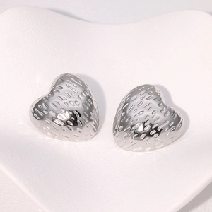 Detailed view of silver heart-shaped stainless steel earrings with hammer texture finish
