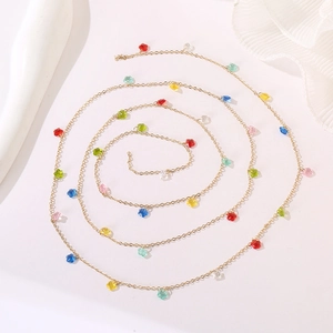 Macro shot of colorful star pendants on a golden long chain in a spiral layout