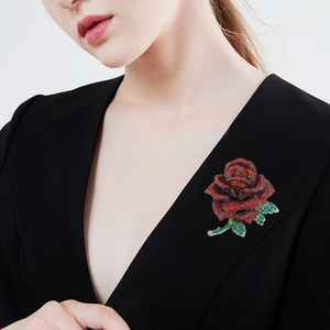Red rose rhinestone brooch pinned on a black suit jacket lapel for a luxury fashion look