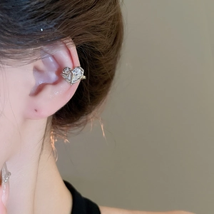 Detail of heart-shaped ear cuff with zircons shown on model's ear without piercing
