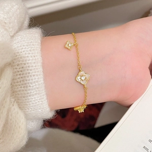 Bracciale placcato oro 18 carats con fiore in madreperla e ciondoli in zircone lucido