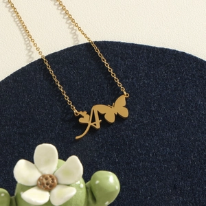 Golden stainless steel necklace featuring a butterfly with cursive letter A pendant