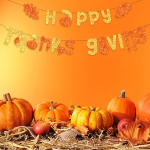 Glittery Happy Thanksgiving banner hanging above pumpkins and autumn maple leaves