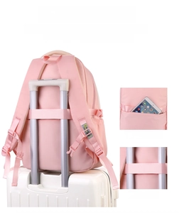 Detail of pink nylon backpack with anti-theft back pocket and luggage strap attachment