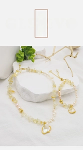 Macro shot of baroque pearl and citrine necklace on stone with natural elements