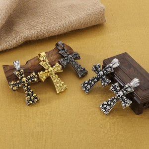 Detailed macro shot of vintage skull cross pendants in gold, silver, and black metal