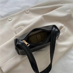 Black PU leather baguette underarm bag with green wallet showing interior capacity