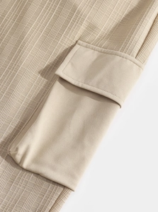 Détail du pantalon cargo beige montrant la poche latérale et le tissu texturé