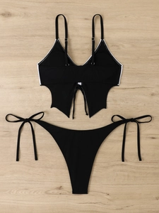 Detail of black bikini set featuring butterfly print with white trim and tie-side closure