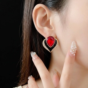 Vintage style heart earrings with red teardrop stone and crystal halo on a black base