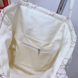 Detail of the quilted bag interior featuring a zippered pocket and red heart stitching