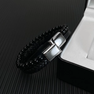 Close-up of black braided leather men's bracelet with beads and metal magnetic clasp