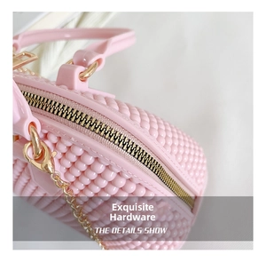 Detail shot of pink jelly bag with pearl texture and golden metal chain hardware