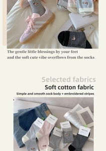 Detail of soft cotton crew socks with fine stripes and dog embroidery in various colors