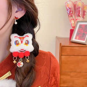 Close-up of plush lion dance hair clip with red tassels and bell for Lunar New Year