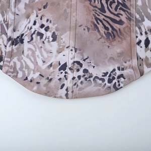 Detailed view of leopard print corset hem with fine stitching and curved fabric edge