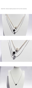 Detailed close-up of pearl and black onyx beads on a slim minimalist gold and silver chain
