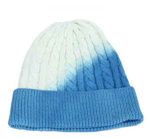 Dettaglio della maglia a trecce sfumata blu e bianca e bordo a coste sul berretto invernale