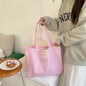 Detail view of pink and white striped canvas tote bag showing the side profile and texture