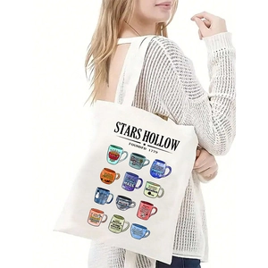 Detail of white canvas tote bag featuring Stars Hollow colorful mug illustrations
