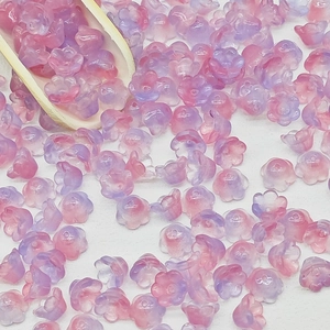 Macro shot of 7x12mm lily of the valley gradient beads with a small wooden scoop