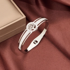 Polished silver stainless steel bangle with diamond-set tree of life openwork emblem