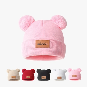 Winter knit baby hat with double fur pom poms and mini label in various colors