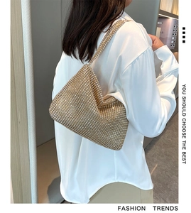 Detail of model carrying gold rhinestone shoulder bag with high-shine crystal finish