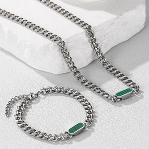Macro shot of silver Cuban link necklace and bracelet set with green striped shell inlays