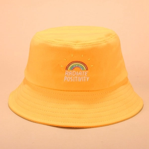 Détail de la broderie arc-en-ciel et du texte sur le chapeau bob en coton jaune vif