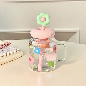 High-capacity floral glass tumbler with pink donut lid and flower straw on desk