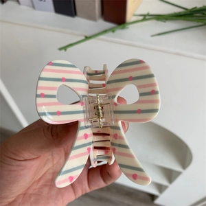 Detail of butterfly hair claw clip with heart stripes and durable gold metal spring