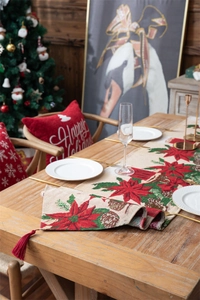 Close-up of Christmas table runner featuring poinsettia jacquard and red tassels