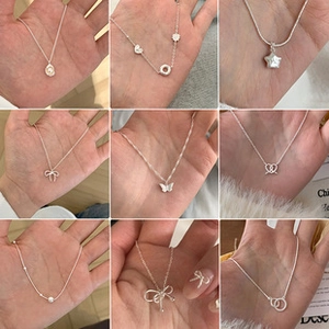 Close-up of nine assorted S925 silver pendant necklaces featuring pearl and heart designs