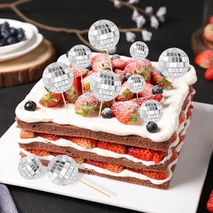 Silver disco mirror balls of various sizes used as toppers on a chocolate cake