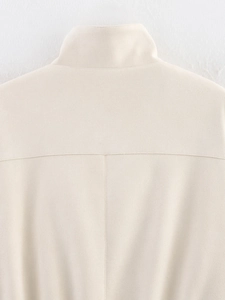 Detail view of the cream faux suede jacket's stand collar and fine stitching on the shoulder