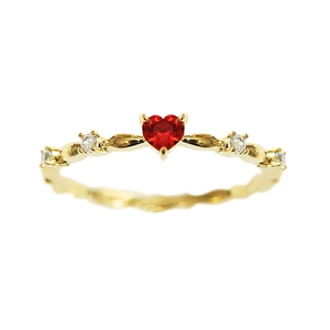 Elegant gold ring featuring a heart-shaped red zircon with twisted band design
