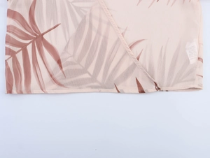 Detailed macro view of chiffon fabric with palm leaf print and finished seam quality