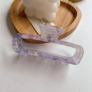 Close-up of lavender marble acetate hair claw clip on heart-shaped wooden tray