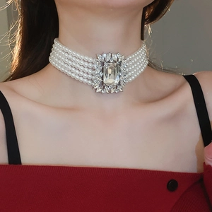 Close-up of a luxury five-row pearl choker necklace with a large crystal centerpiece