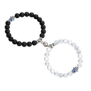 Detail of magnetic stone bracelets with black and white beads and Hamsa hand charms