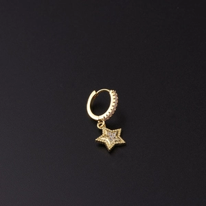 Detail of gold huggie earrings with micro-pave star pendants and zircon accents