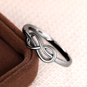 Macro-opname van minimalistische ring met oneindigheidssymbool en donkere metallic finish