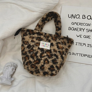 Detail shot of leopard print plush handbag with rainbow logo label and zipper closure