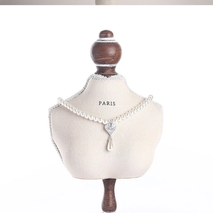 Detailed view of a pearl necklace with water drop pendant on a Paris mannequin stand